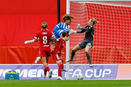 Madison Haley heads in while being challenged by two defenders and Liverpool’s goalkeeper